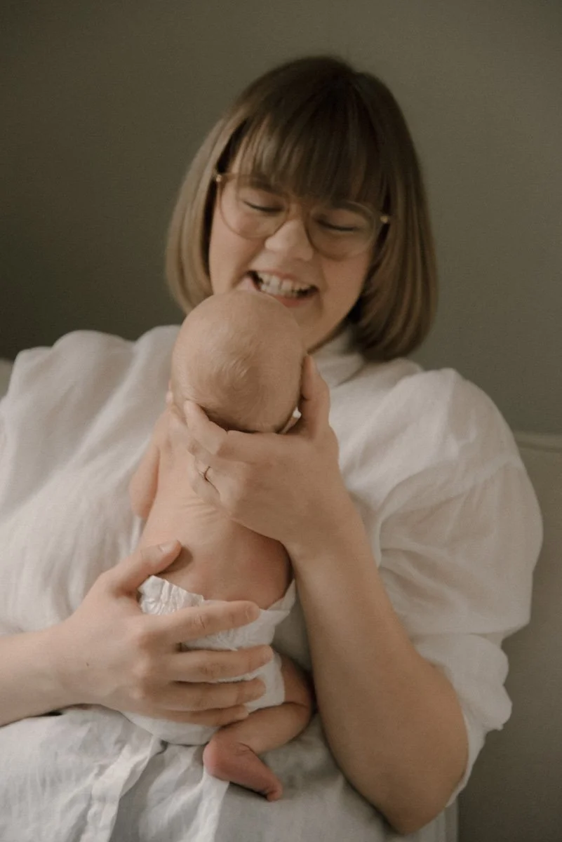 Iloinen ja onnellinen äiti pitelee vauvaansa. Vauvakuvaus kotona.