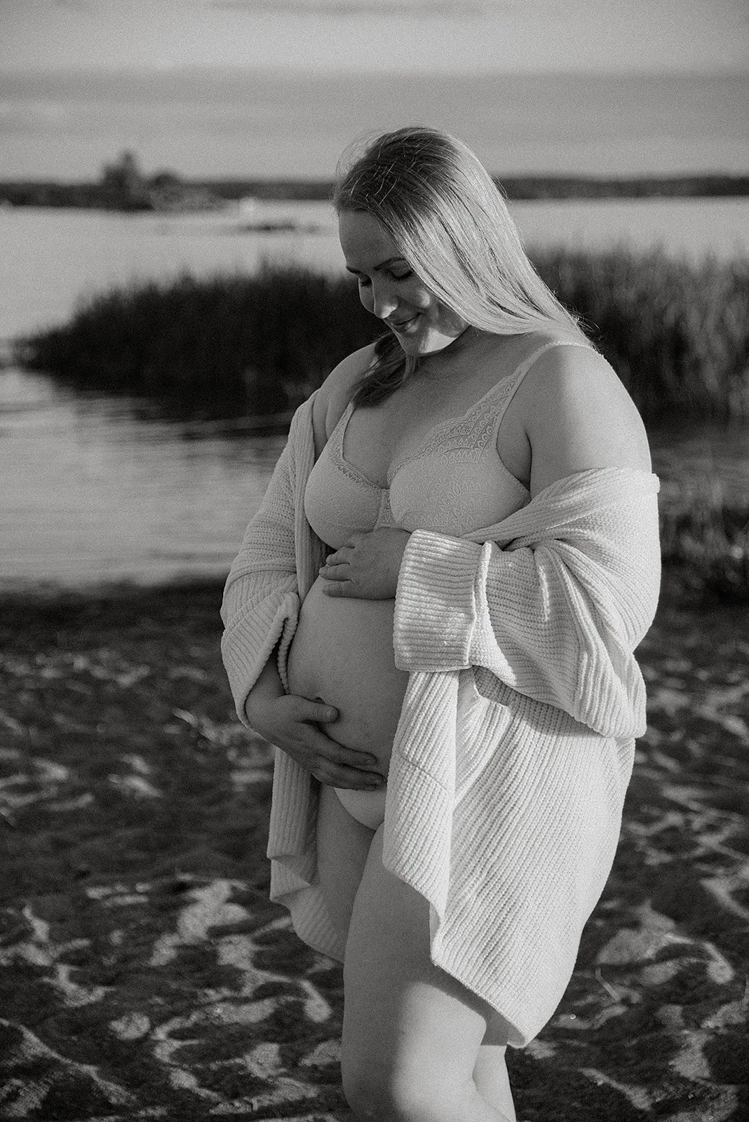 Äidin ja tulevan vauvan yhteinen hetki. Raskauskuvaus merenrannalla.