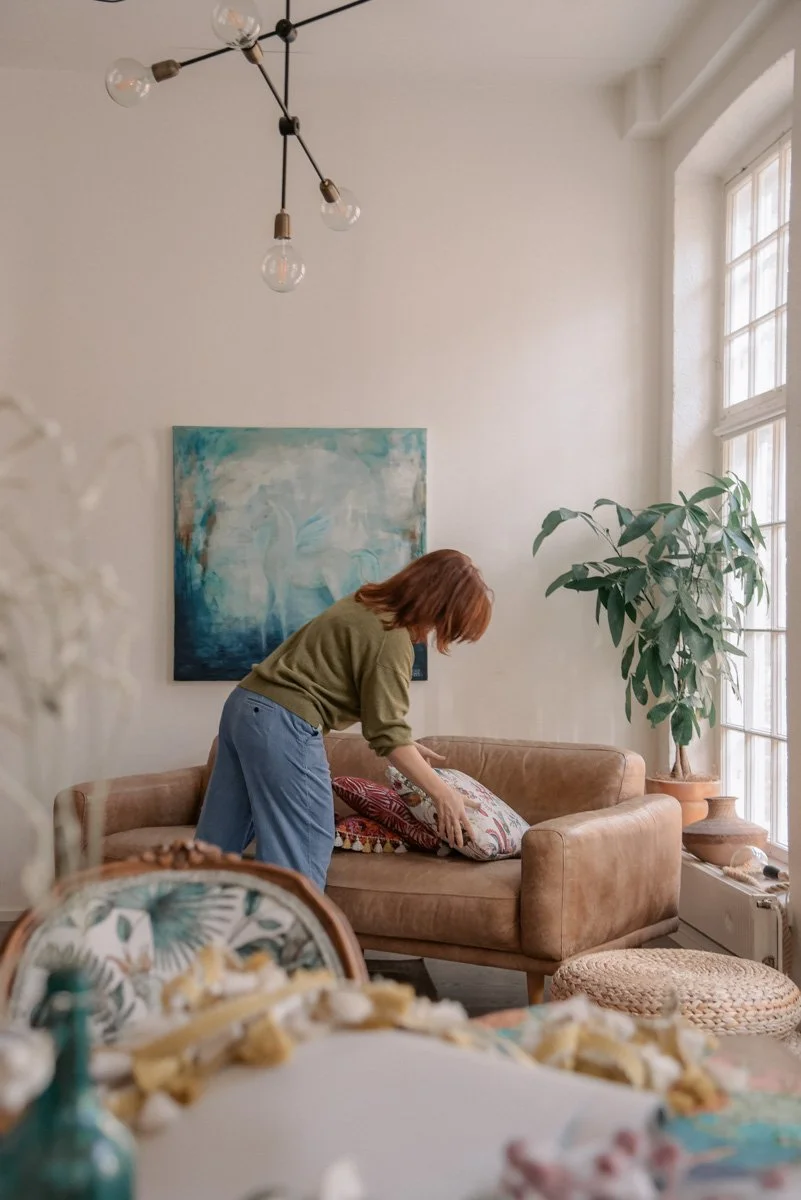 Verhoomoyrittäjä Virve asettelee värikkäitä tyynyjä sohvalle. Kuvannut yrityskuvaaja Heidi Väisänen.