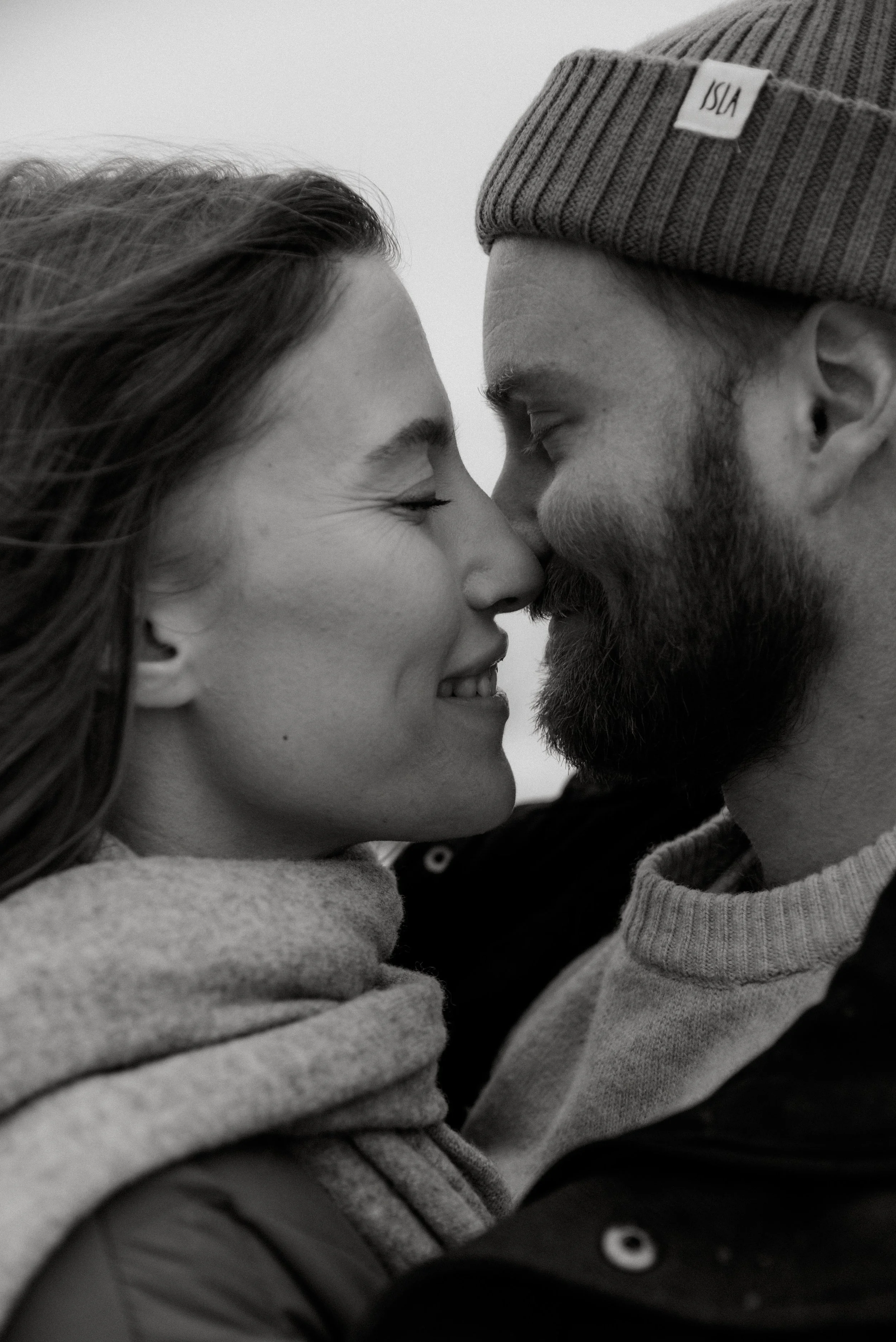 Mustavalkoinen pariskuntakuva, jossa mies ja nainen hymyilevät toisilleen.