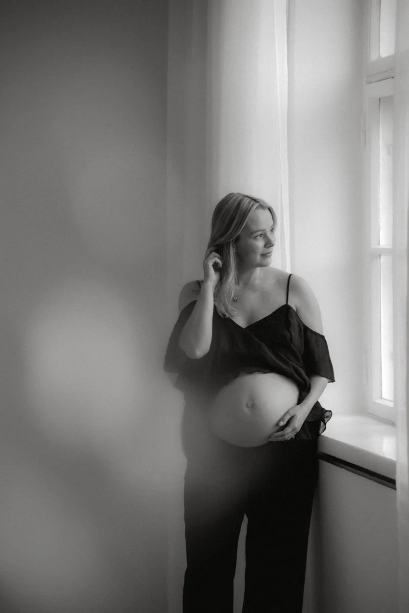 Mustavalkoinen potretti, jossa odottava äiti ikkunan äärellä. Kuvan on ottanut raskausajankuvaaja Heidi Väisänen.