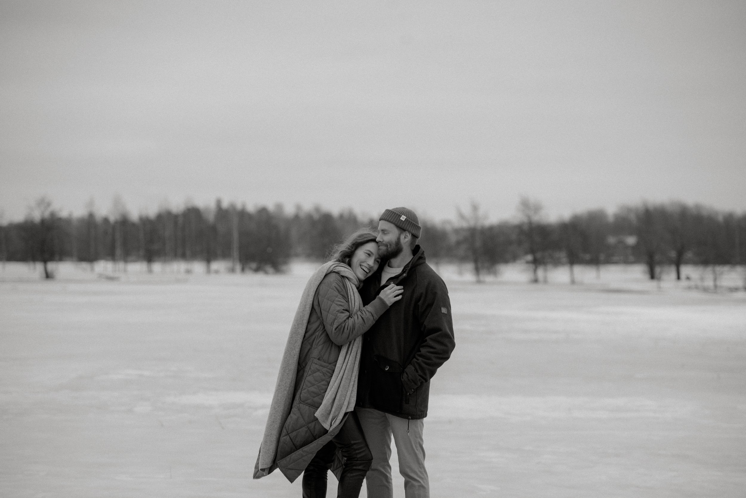 Pariskunta halaa toisiaan talvimaisemassa. Pariskuntakuvaus Espoo.