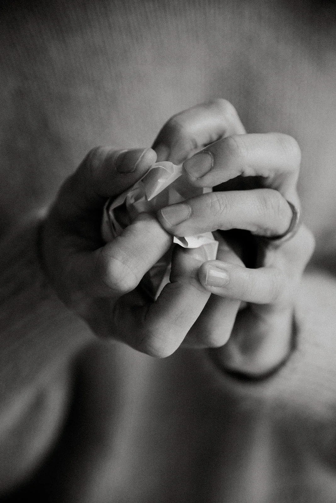 Nainen rypistää paperin mytyksi käsissään.