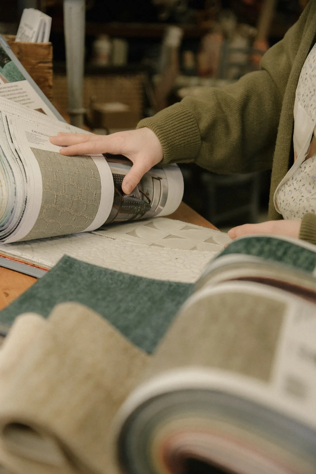 Verhoiluliike Eklundin brändikuvaus, yrittäjä selaa katalogia.