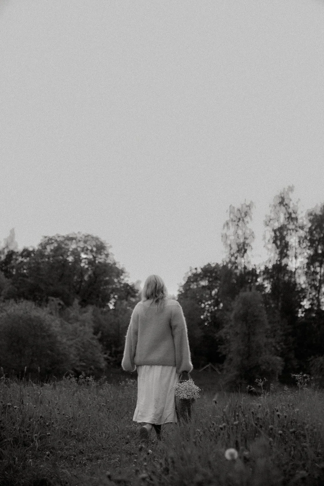 Yrityskuvaus luontomaisemassa. Doula Jutta Alanen kävelee niityllä.