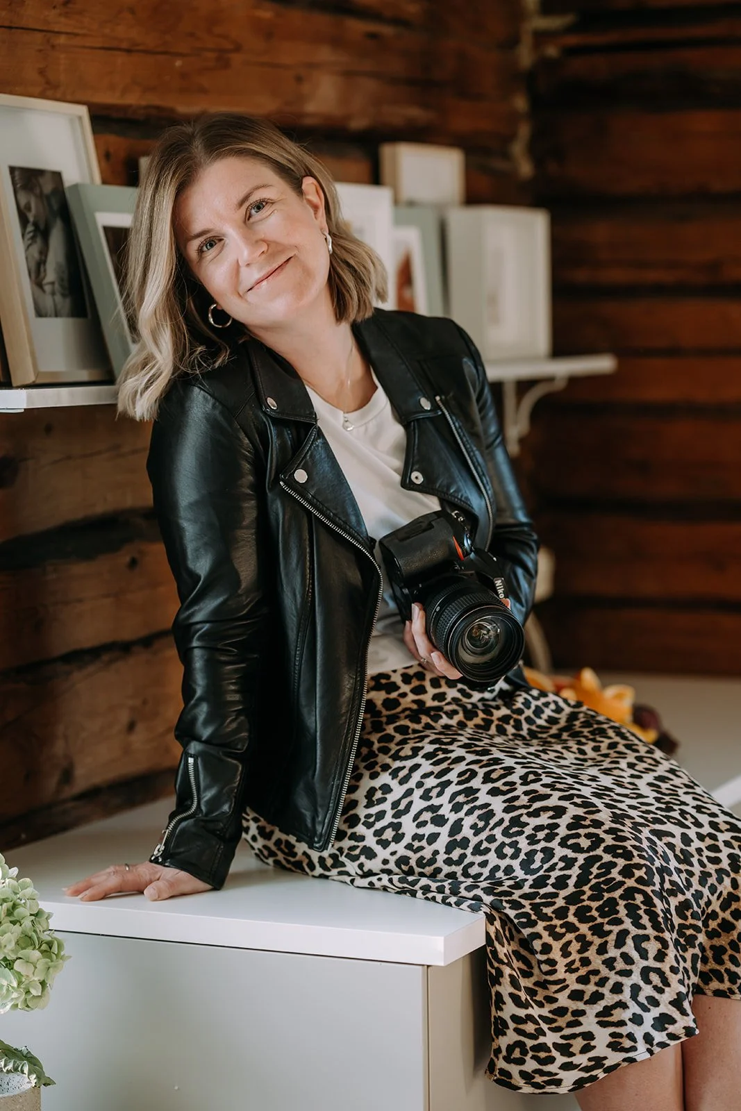 Valokuvaaja Heidi Väisänen istuu ja pitelee kameraa kädessään.