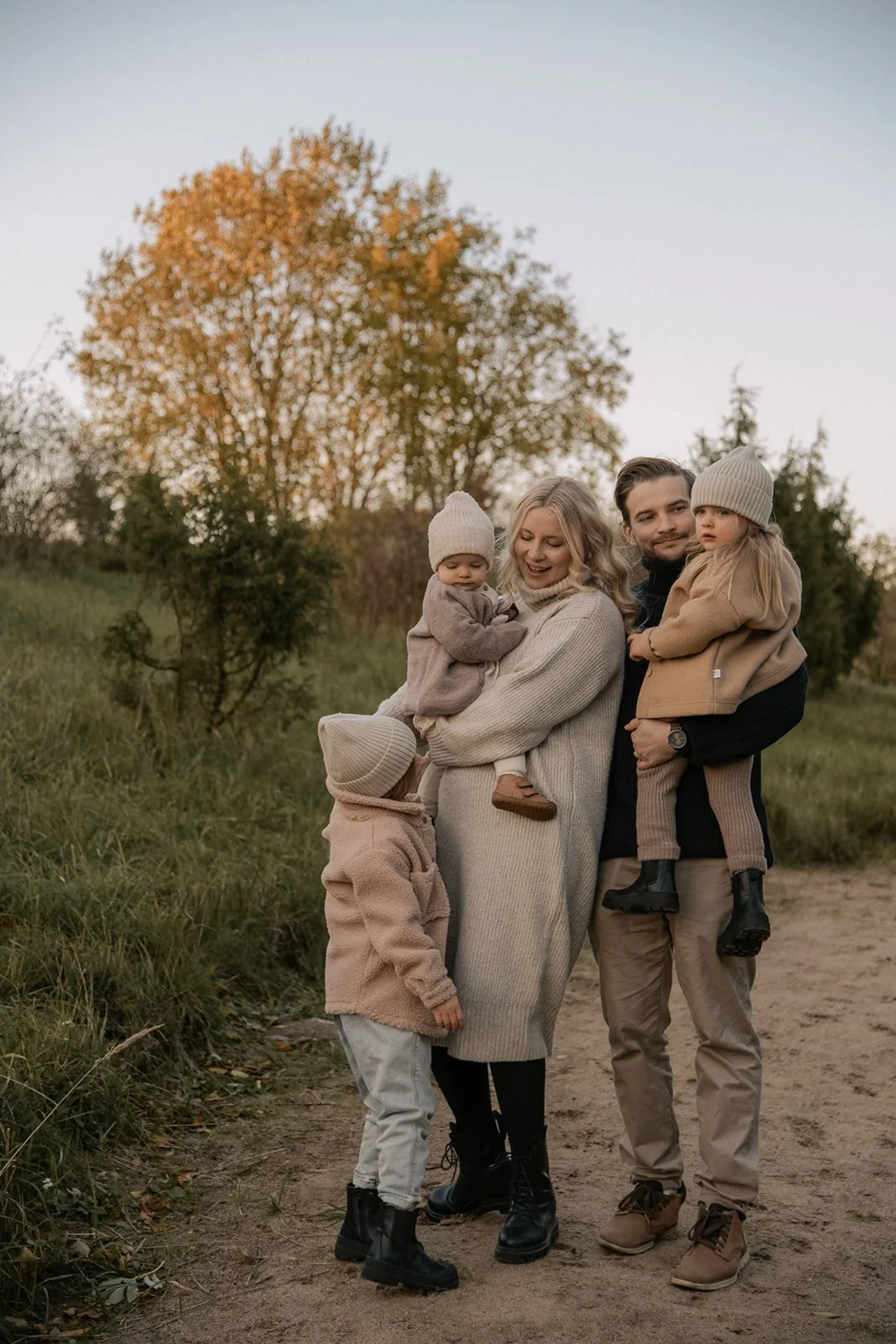 Perhekuvaus syysmaisemassa, vanhemmat ja kolme lasta.