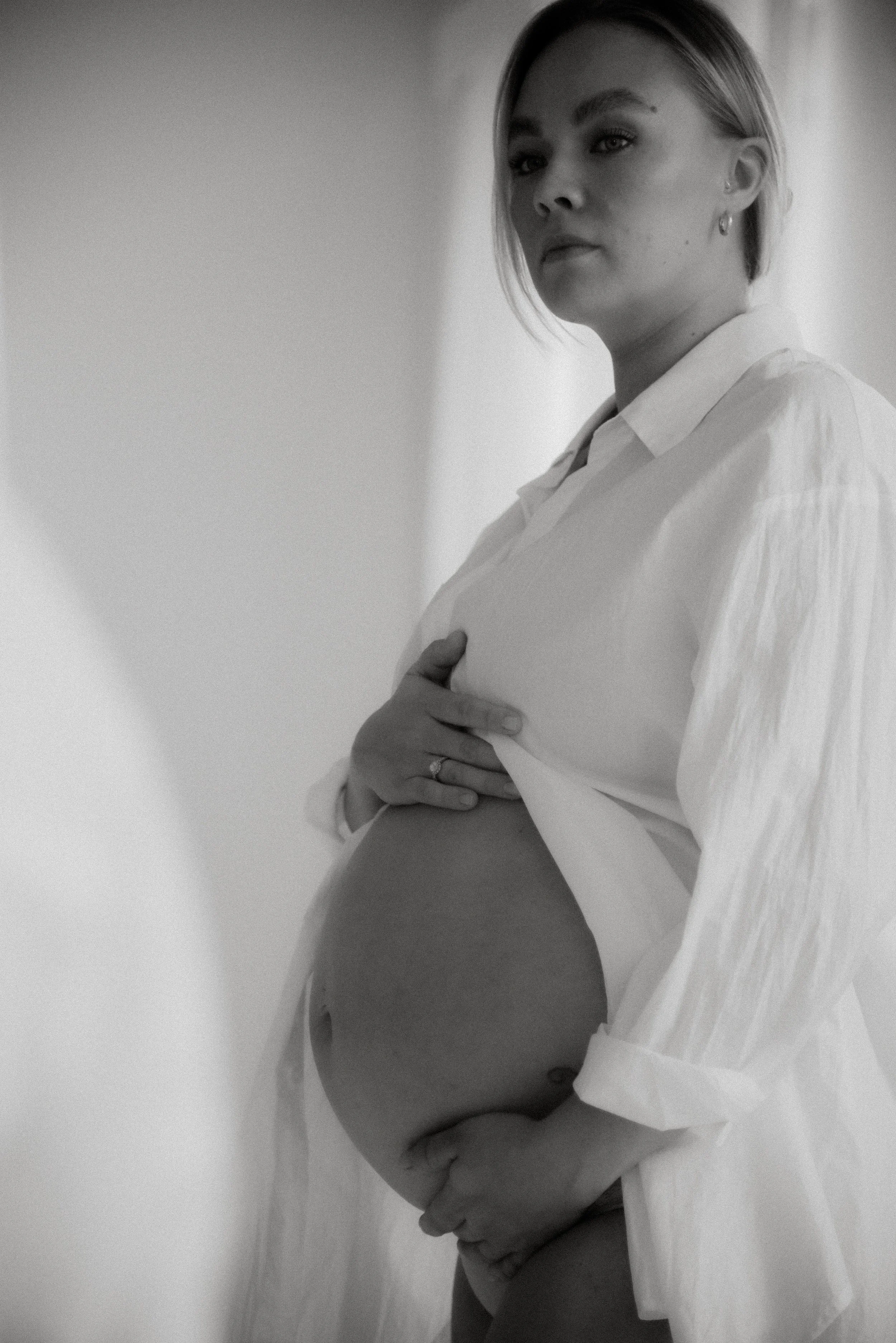 Nainen ja kaunis pyöristyvä äidin vatsa. Odotusuvaus Heidi Väisäsen studiolla Keravan Saviossa.