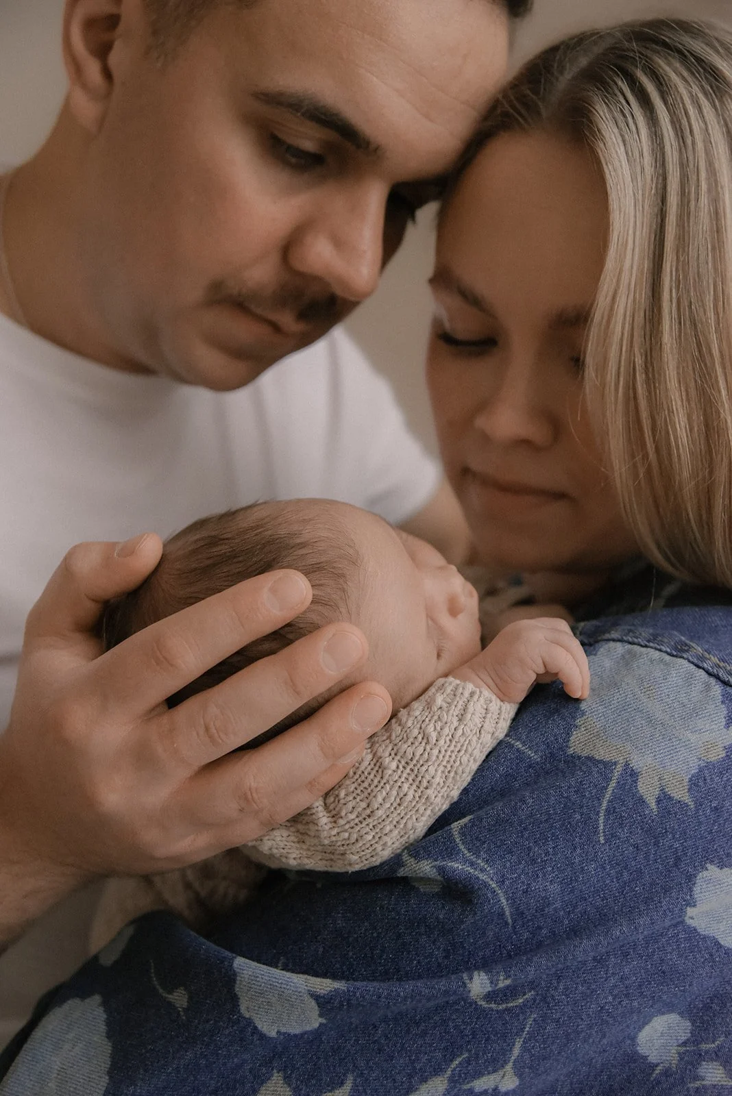 Perhekuvaus, isä, äiti ja vastasyntynyt vauva Heidi Väisänen kuvattavana studiolla.