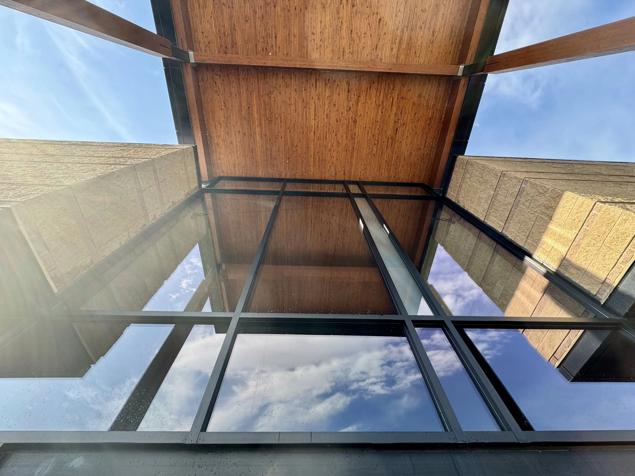 View of a modern city building exterior with large glass windows after pure water window cleaning.