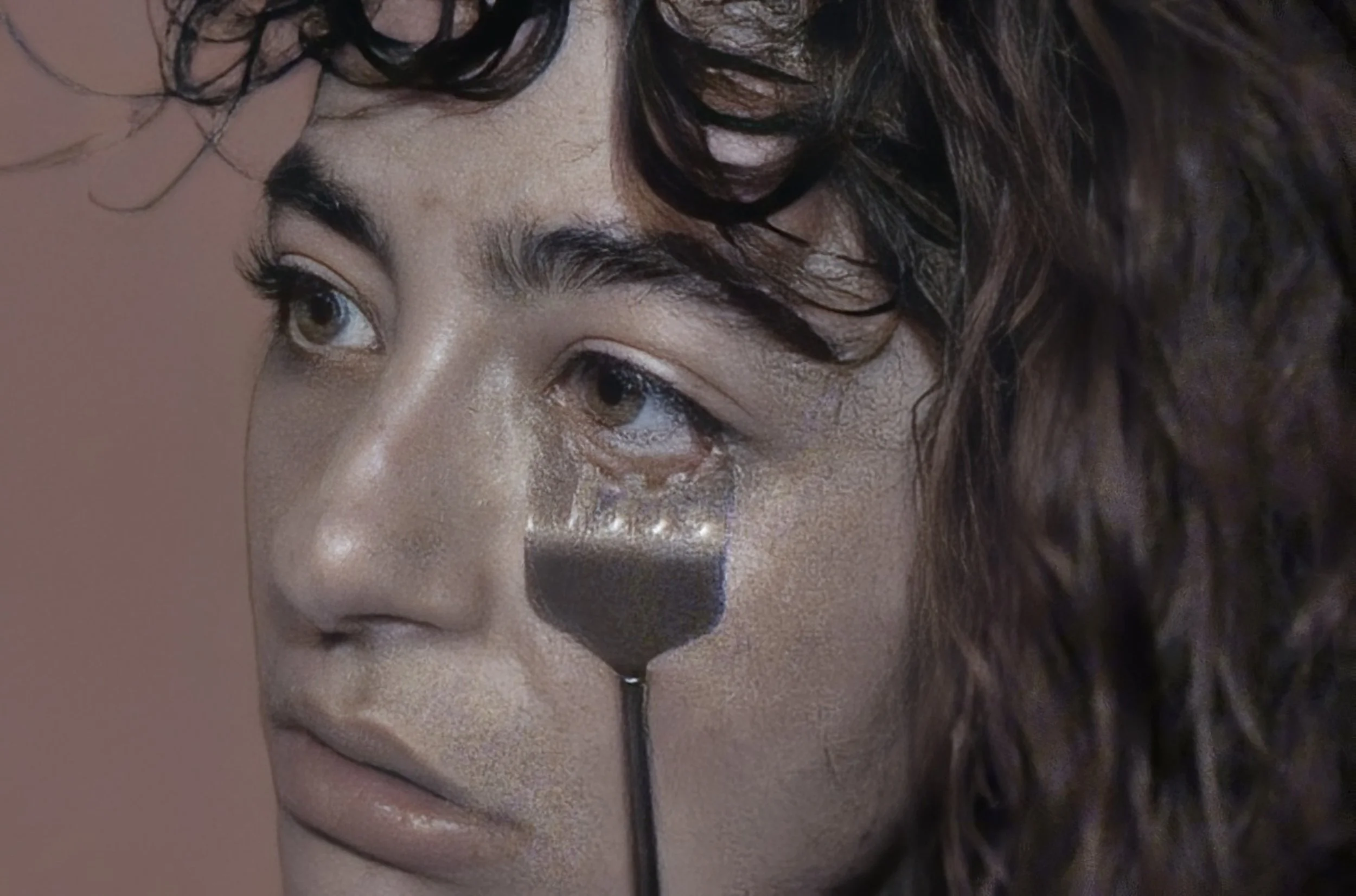 Ragazza con lacrime agli occhi, con un mestolo di cioccolata calda appoggiato sulla guancia