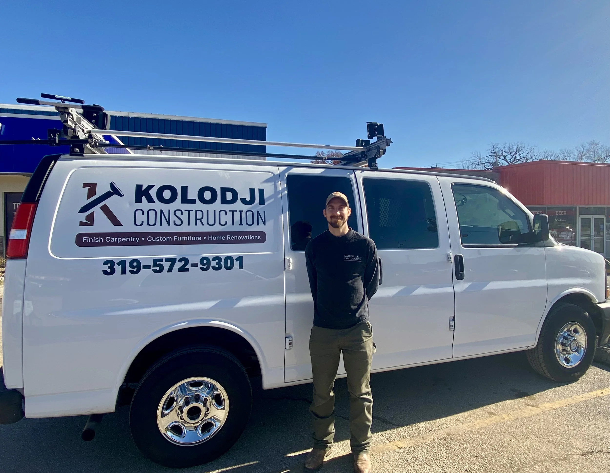 Taylor standing in front of his work truck.