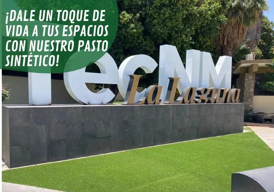 Letrero grande con palabras en inglés y español, promoviendo un espacio con pasto sintético en un área exterior con árboles y vegetación.
