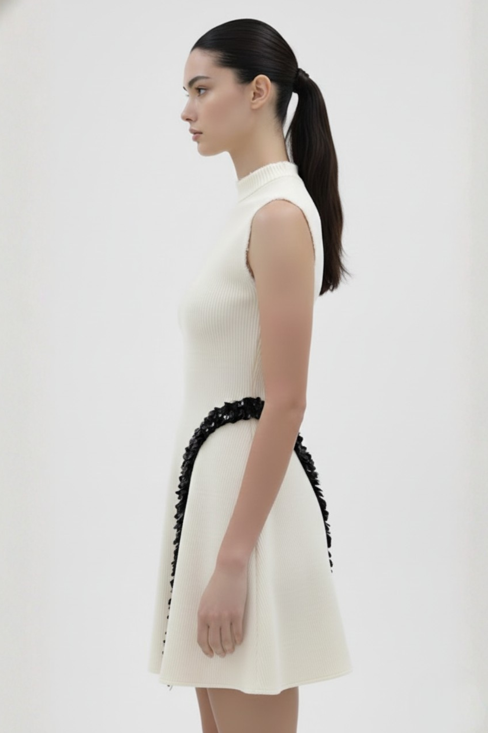 ADRIANNE WEBER Sculpted mini with a high funnel neck and sharp A-line cut and intentional raw edges