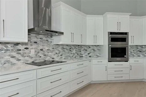 This complete home remodel got a sharp new look. Craftsman shaker cabinets, quartz countertops, all new appliances, and a  modern backsplash to modernize this beautiful home in The Oaks in Osprey