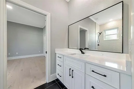 Craftsman shaker cabinets, quartz countertops and sleek new plumbing fixtures for this jack and jill bathroom.