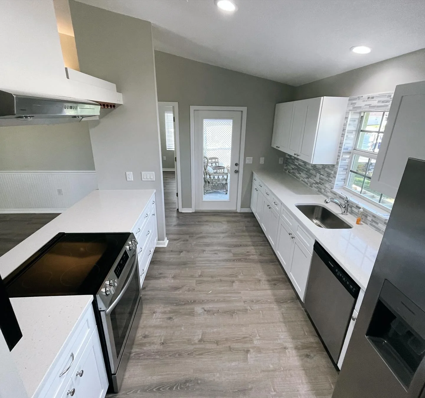 White shaker cabinets are a timeless selection that can be dressed up with countertops and backsplash to give a very elegant look. 