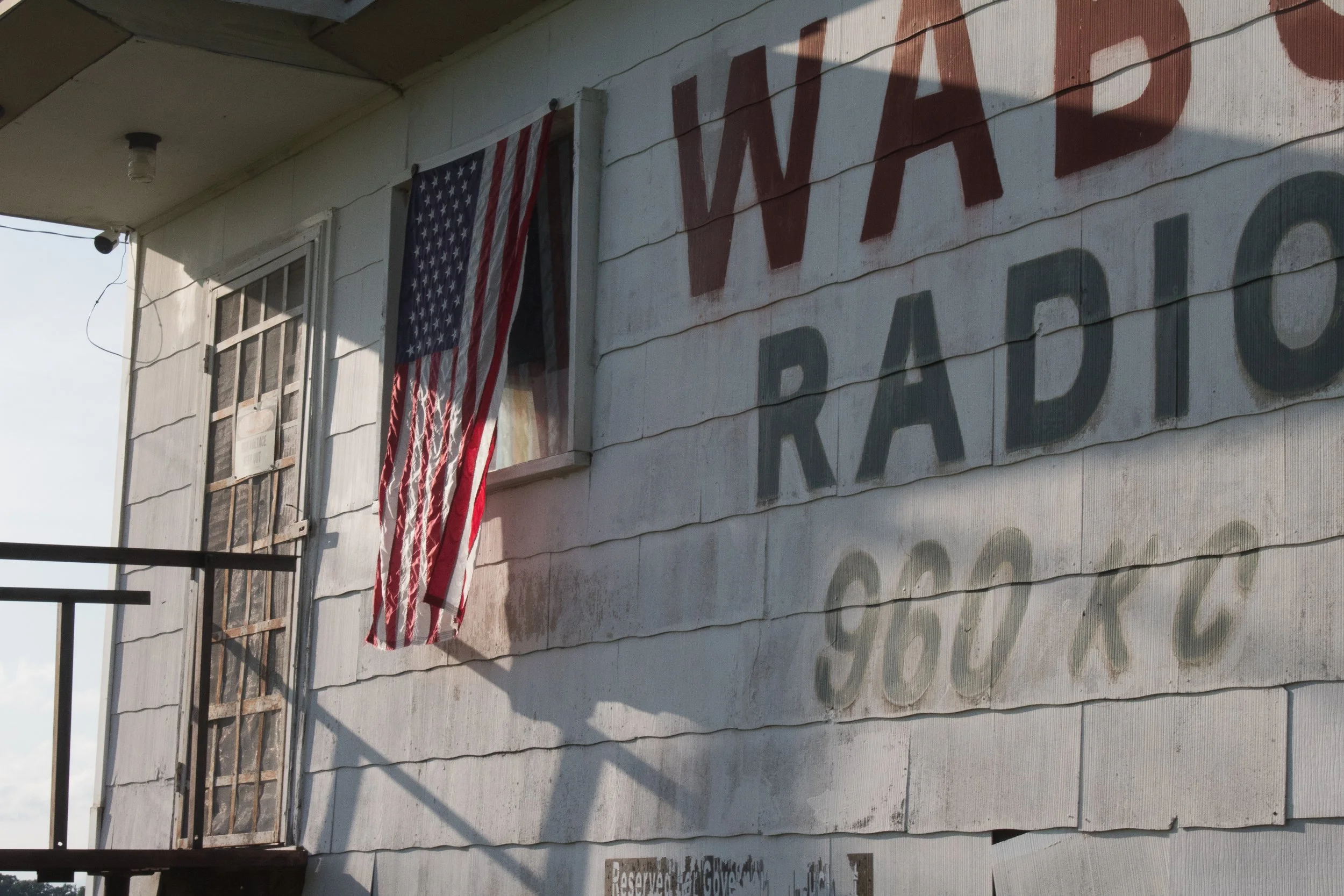 An American flag waves outside a building advertising a radio station.