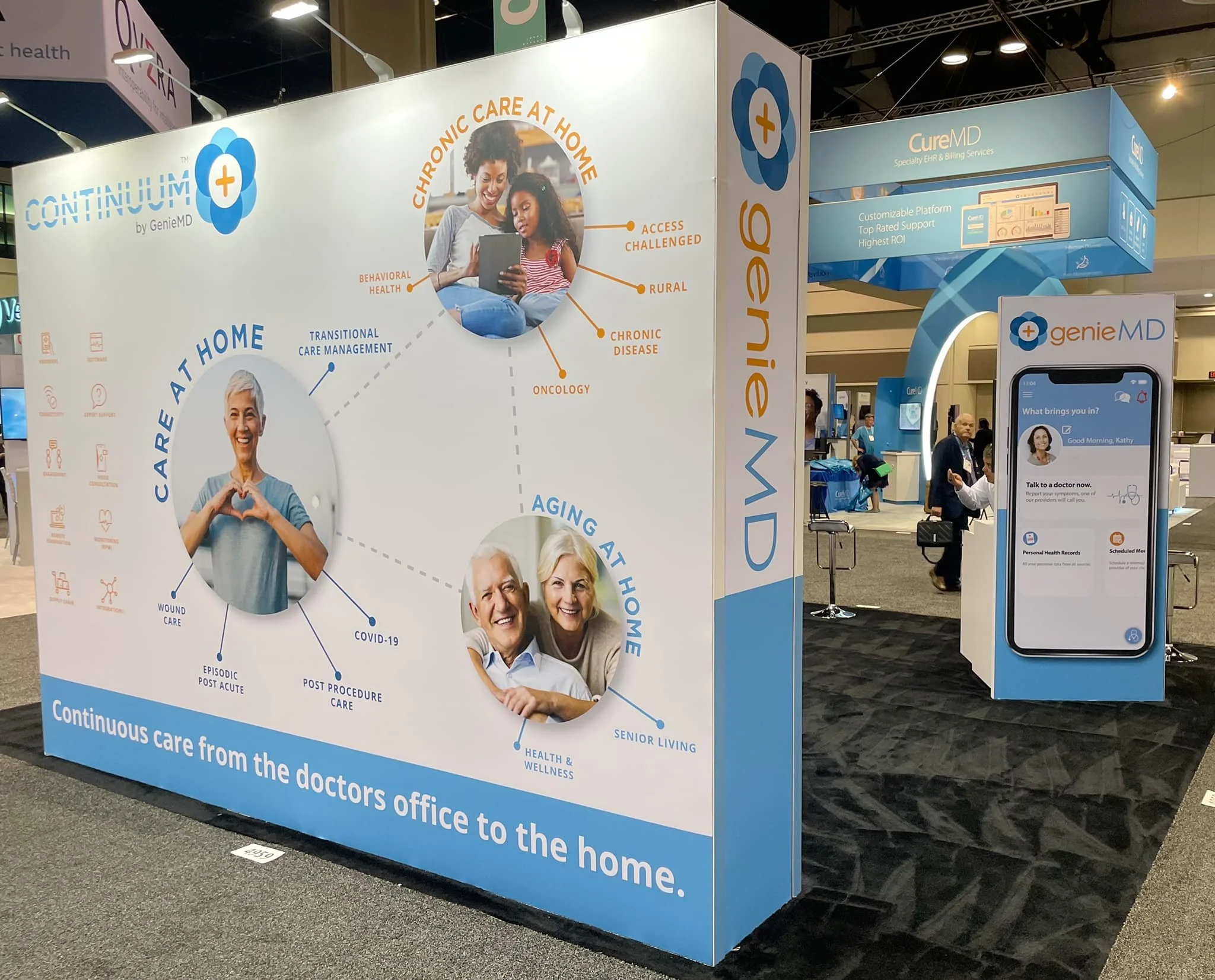 Exhibition booth for Continuum by GenieMD showing digital health services, with graphics of people and text emphasizing care from the doctor's office to home, including chronic care, aging at home, and COVID-19 support.