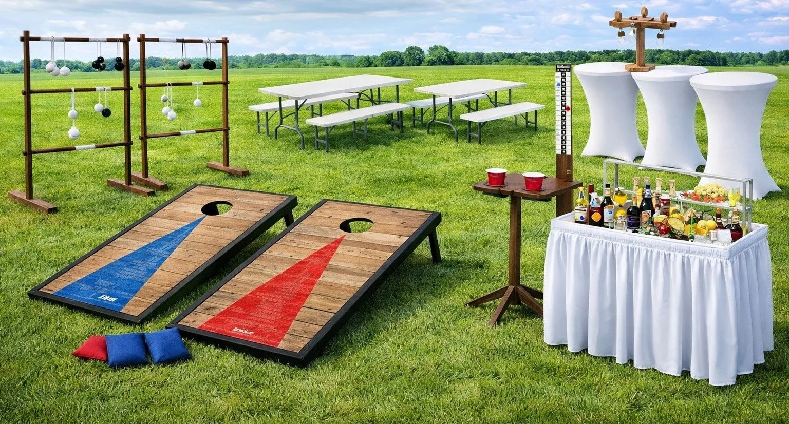 Outdoor carnival or party game setup with cornhole boards, bean bags, giant Jenga, beer pong tables, and a drinks station on a grassy field with a clear sky.