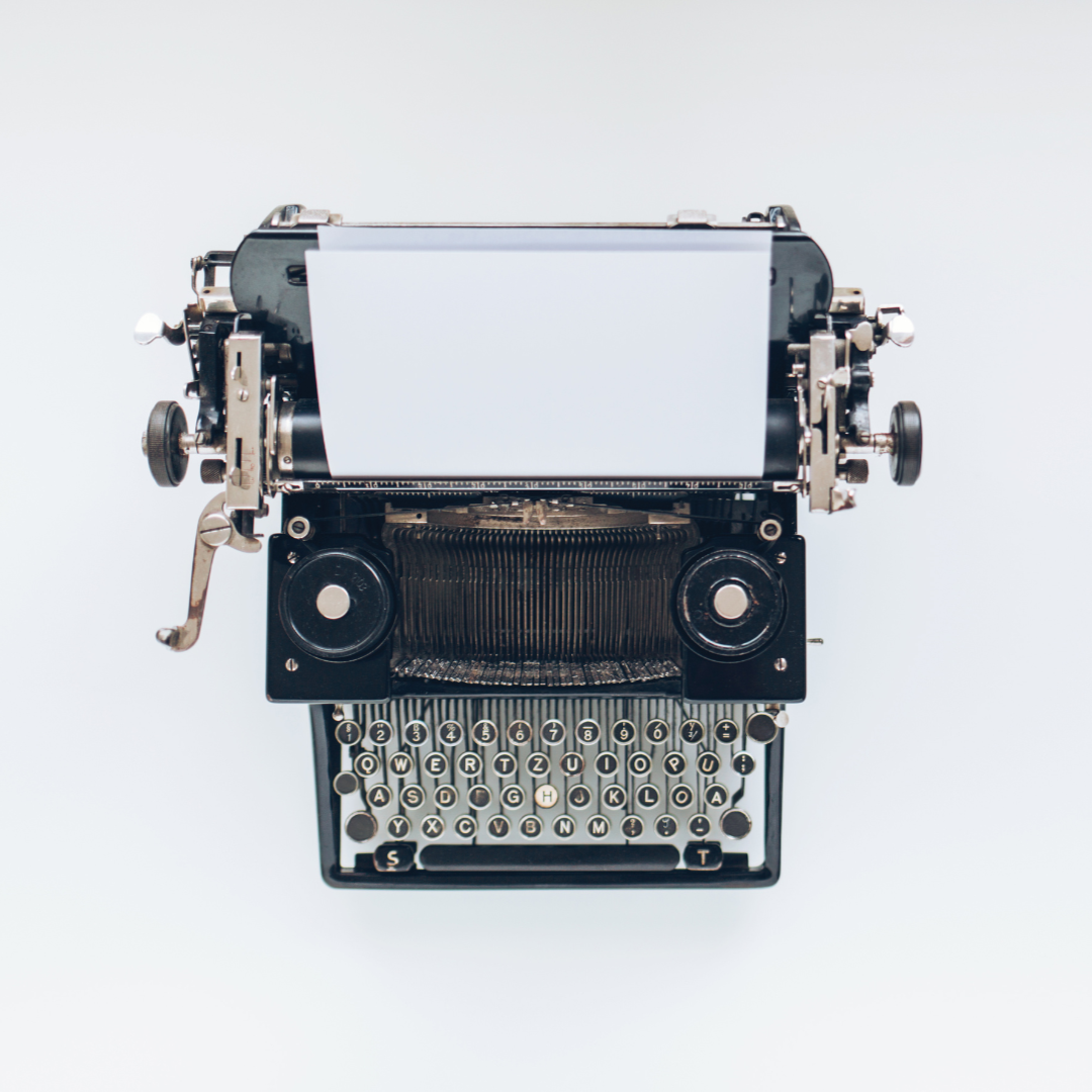 A vintage typewriter with a sheet of paper inserted, viewed from above on a plain white background.