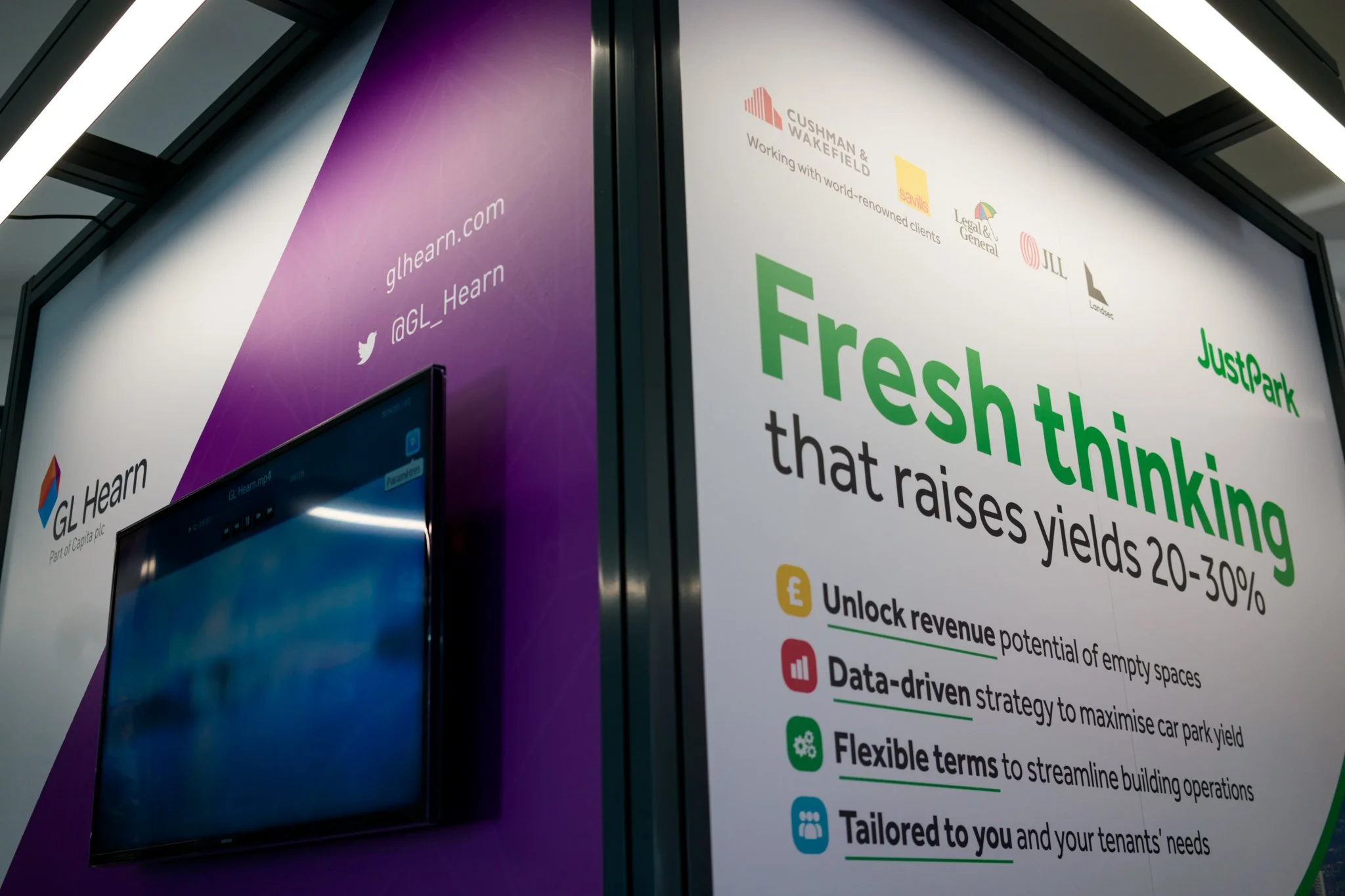 Advertisement for GL Hearn and JustPark, promoting fresh thinking to increase parking lot yields by 20-30%, with icons and bullet points outlining revenue, strategy, terms, and customization