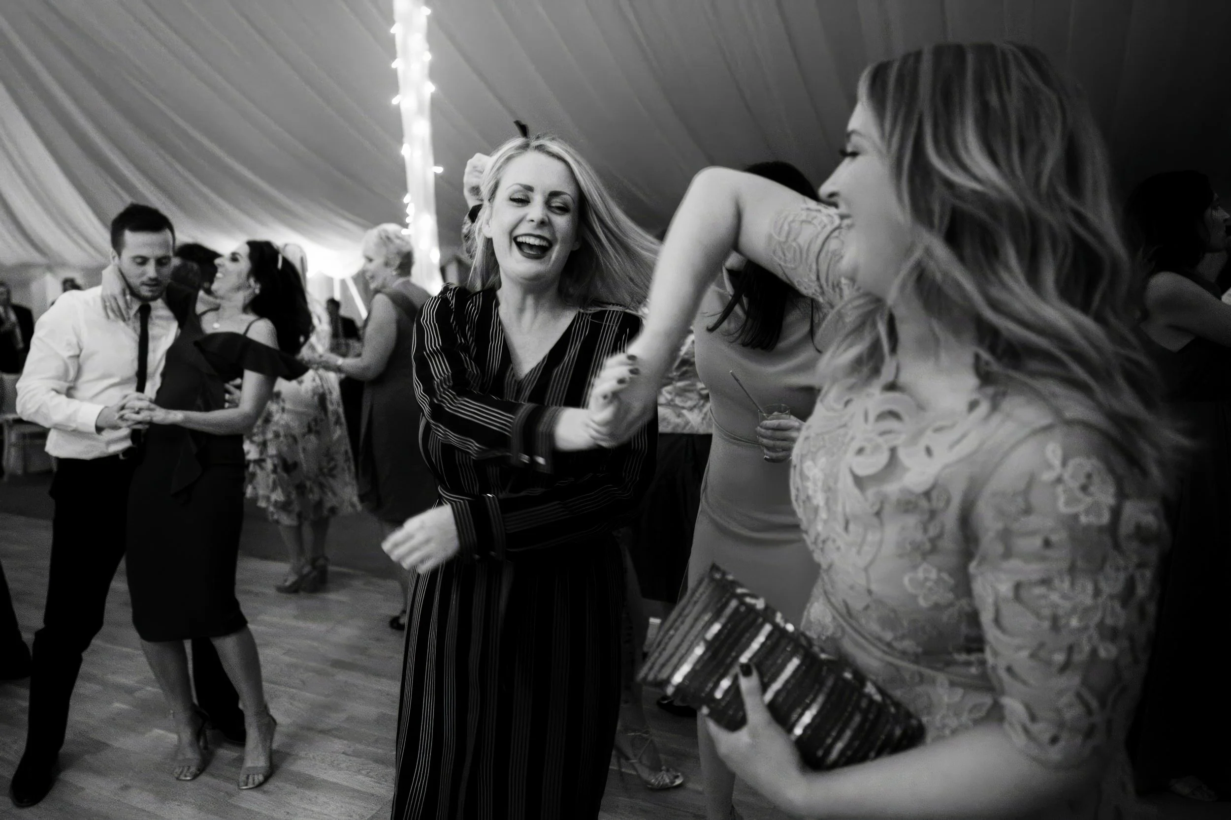 People dancing and socializing at an indoor celebration or party.