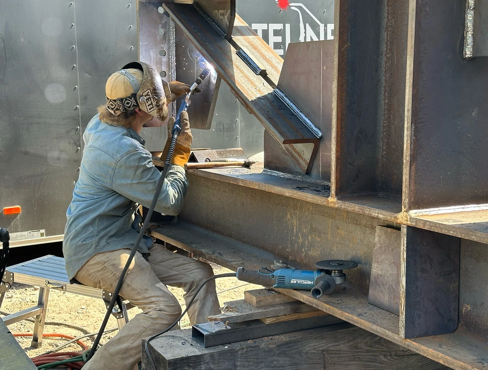 Welder performing steel welding for a custom metal fabrication project