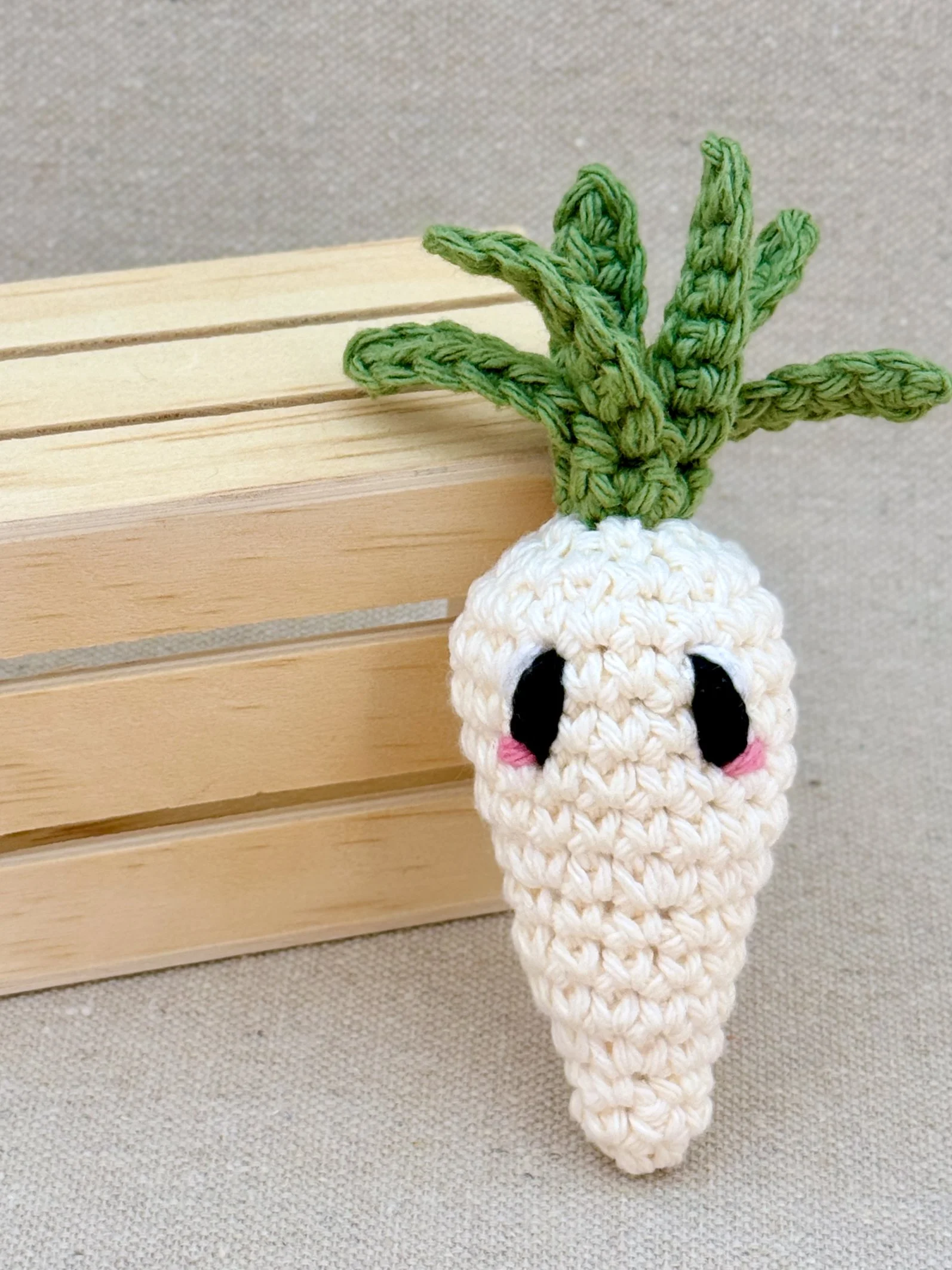 A cream amigurumi carrot plush posed with a mini wooden crate (Copy)