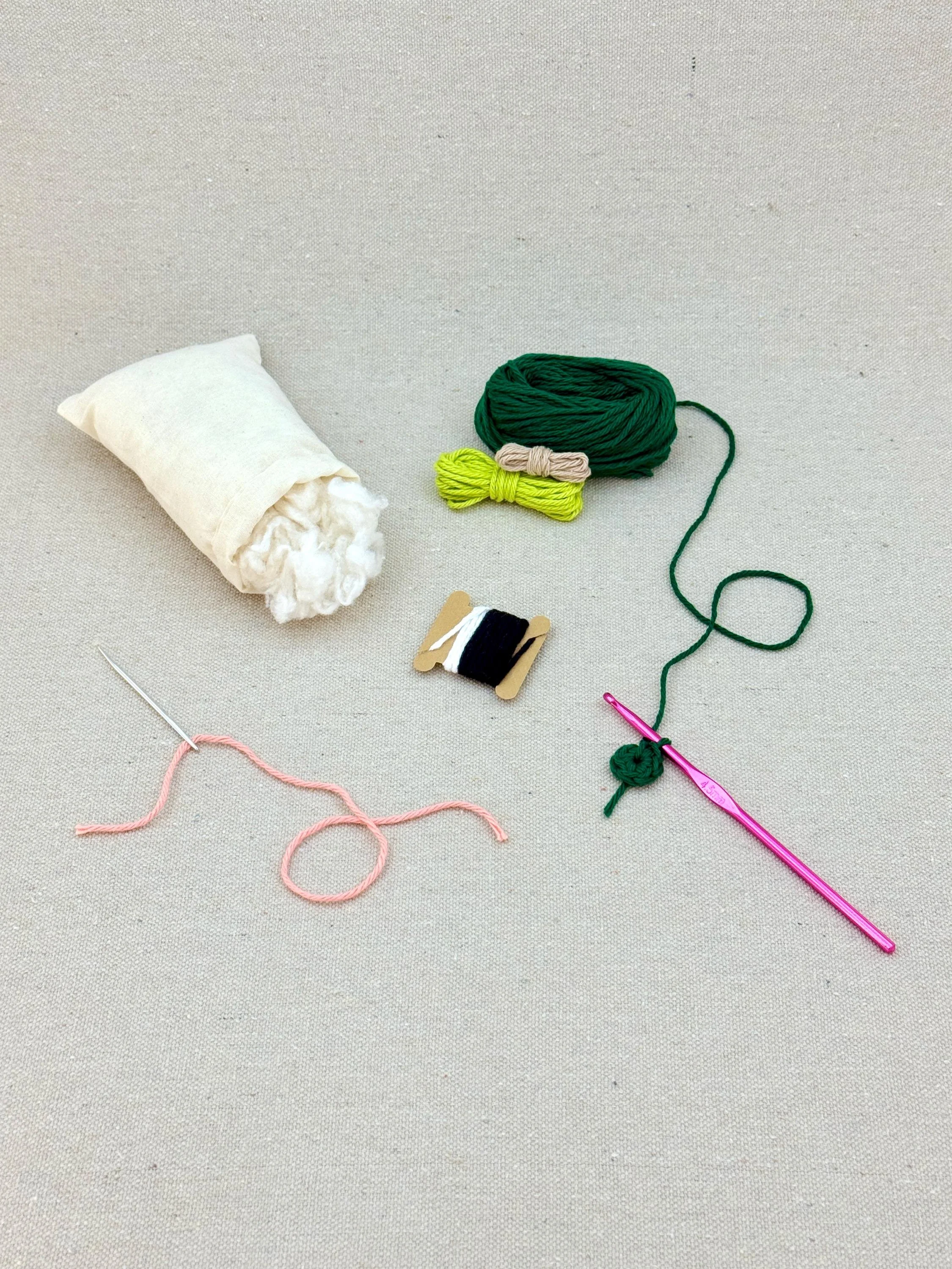 A pine green amigurumi apple mid project using a DIY crochet kit