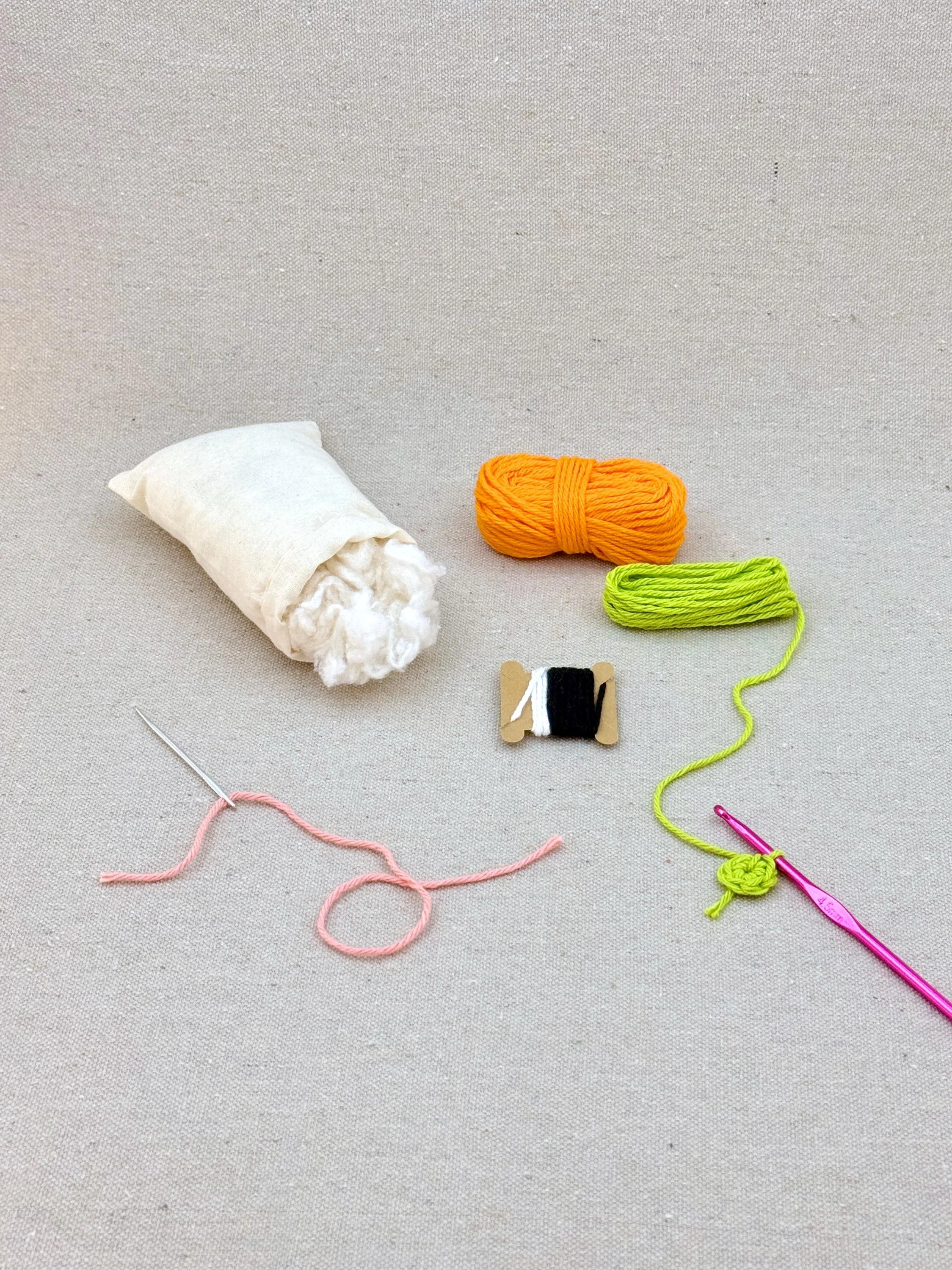 A orange amigurumi carrot mid project using a DIY crochet kit