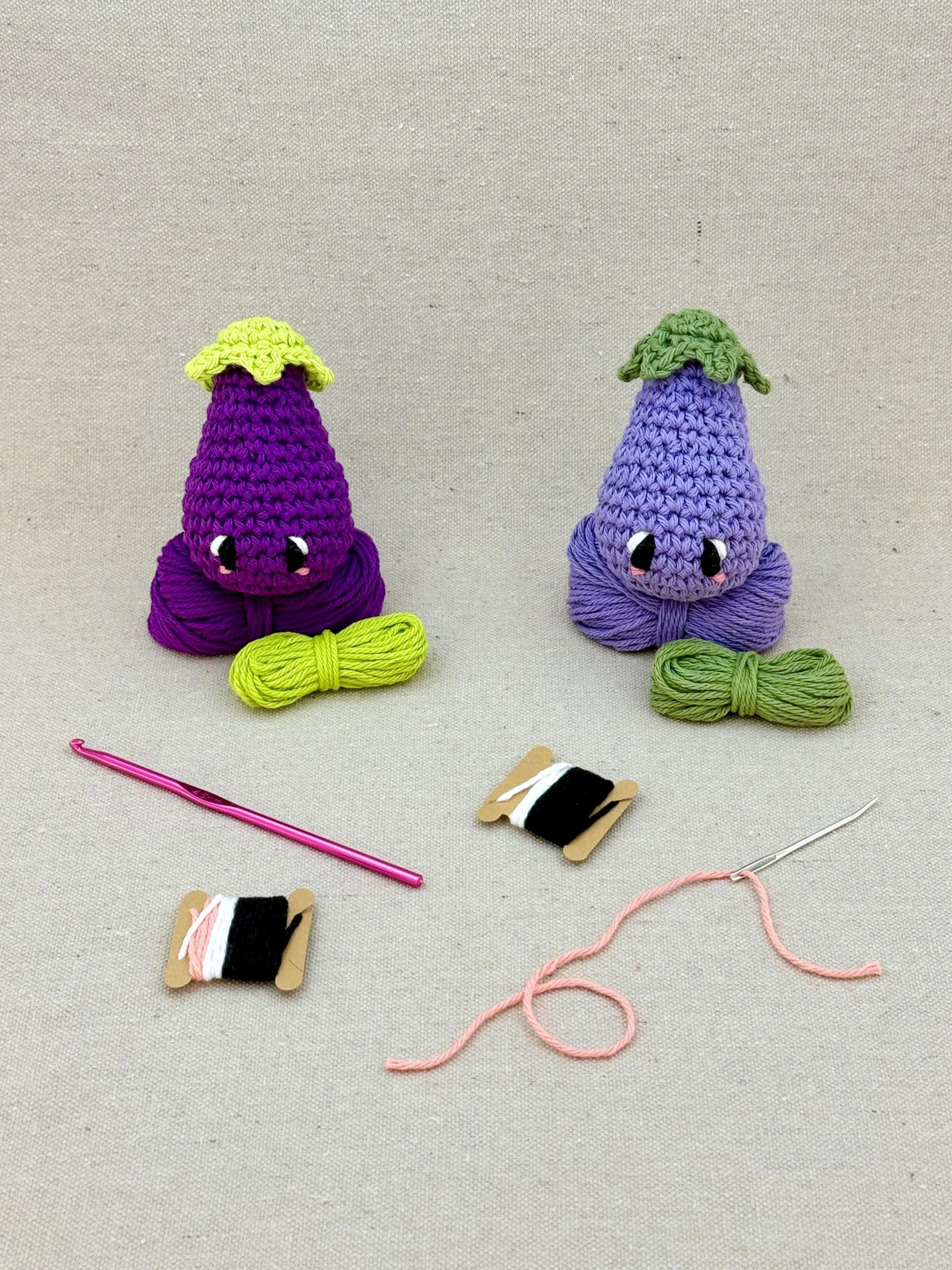Two amigurmi eggplants in dark purple and light purple on matching colour yarn