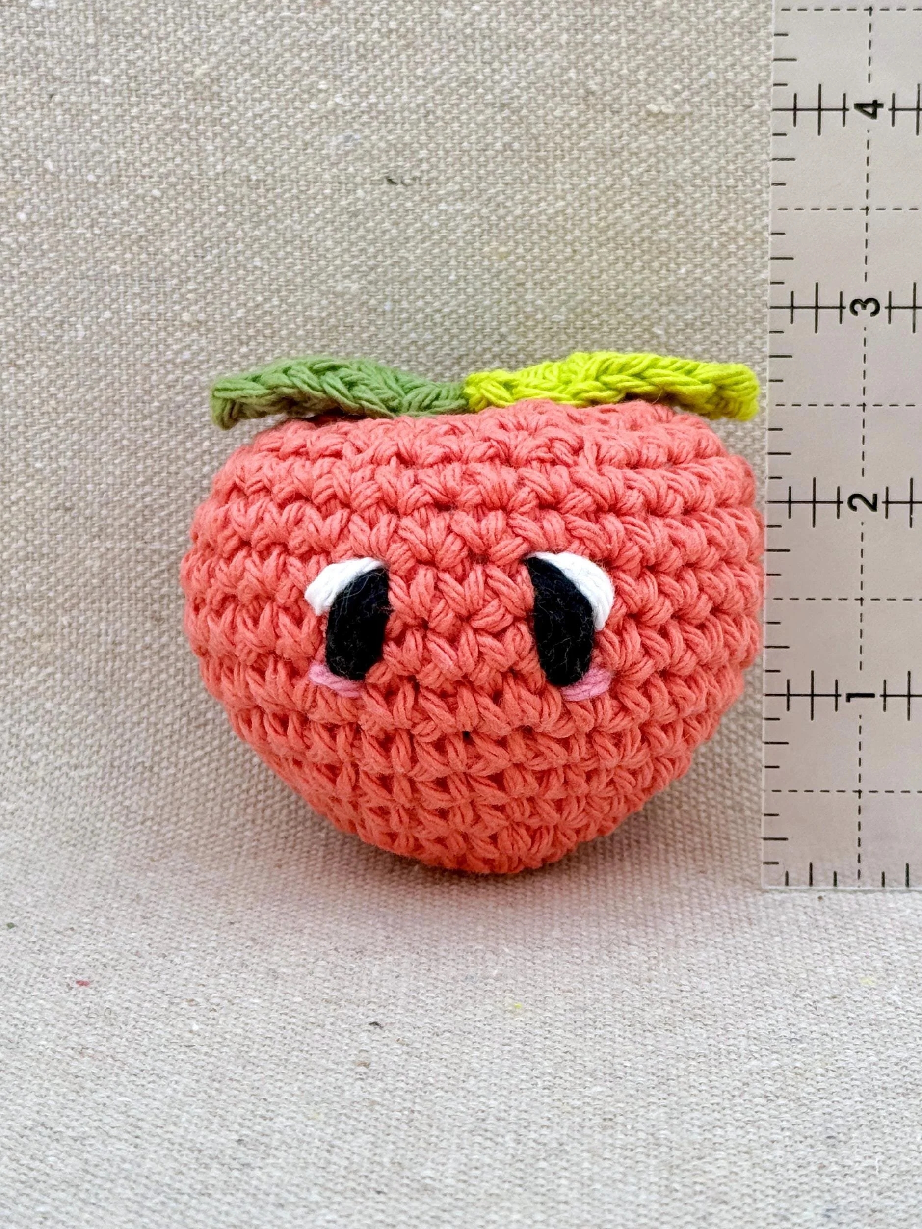 Crochet peach measuring 2.5 inches tall not including leaves