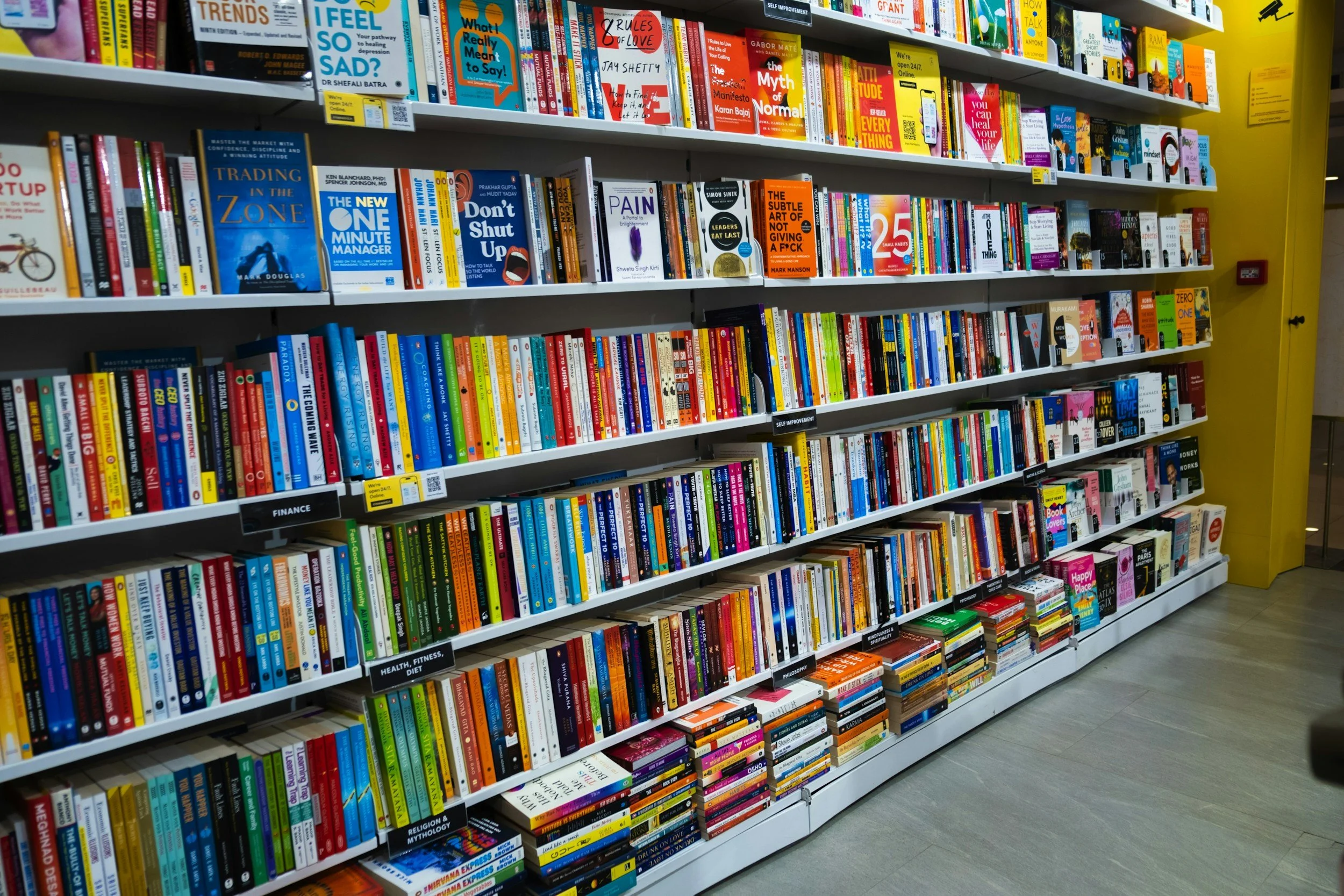 Bookshelves filled with colorful books in a bookstore.
