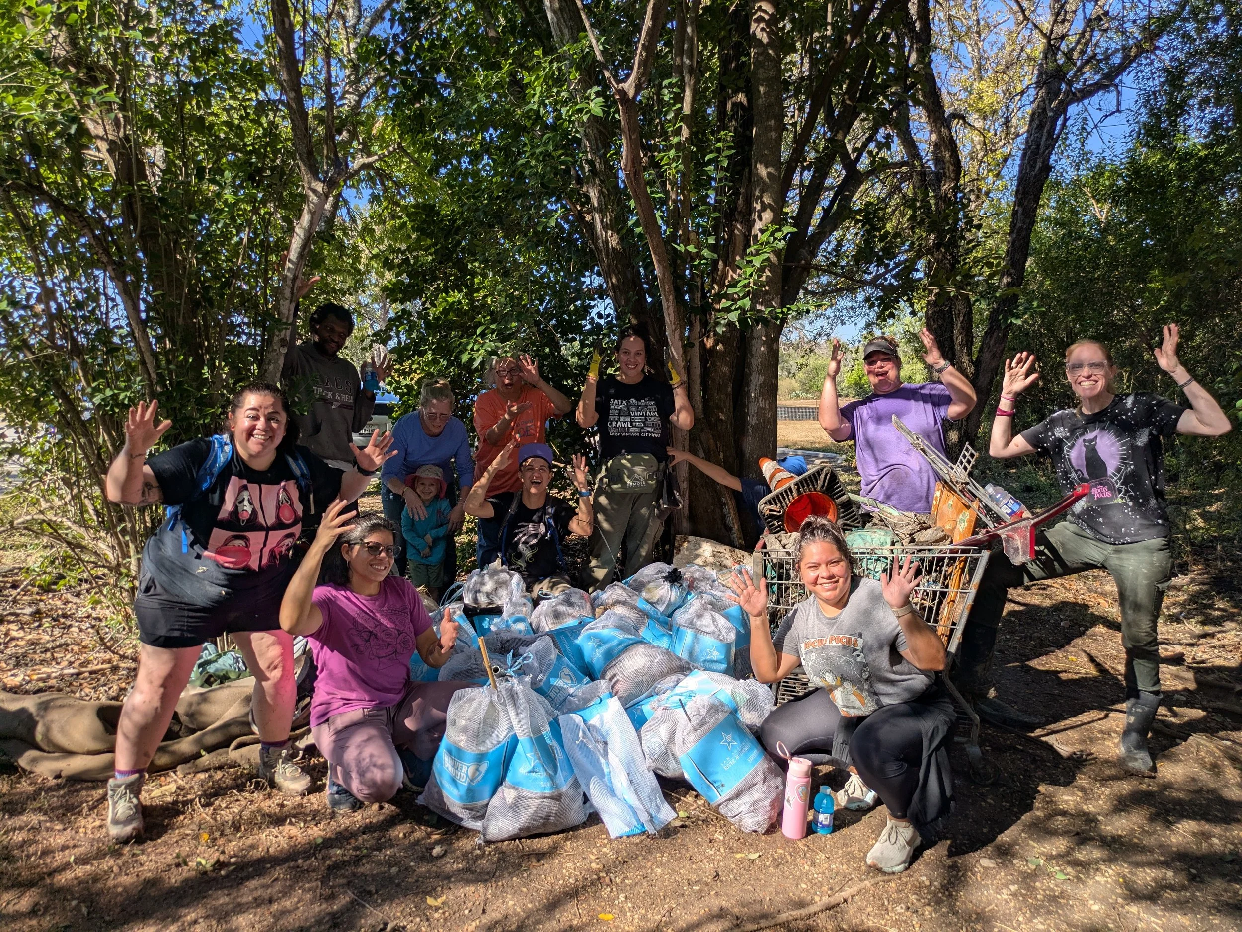volunteers in front of collected trash at Salado Creek in Tobin Park