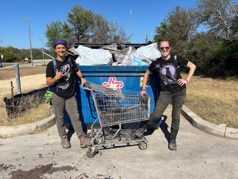 Two volunteers in front of a dumpster and throwing away trash at Tobin Creek