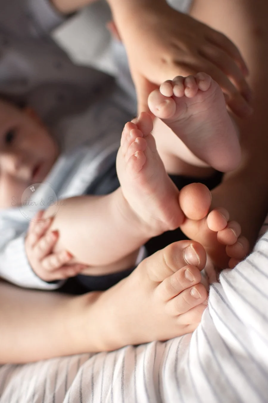 Close-up of a baby's feet being held by an adult's hands.
