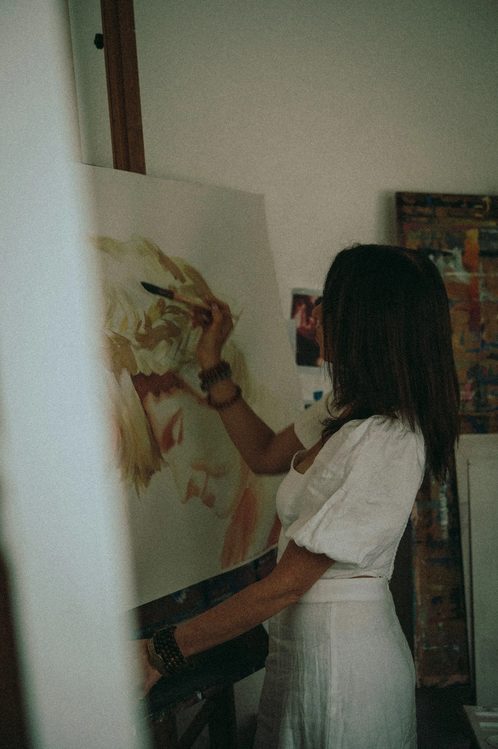 Eine Frau malt ein Bild eines Gesichts auf eine Leinwand.