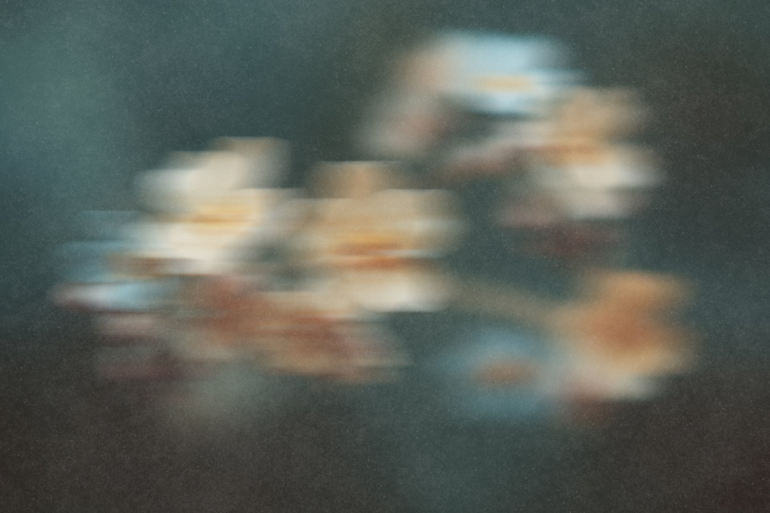 Ein Bild von verschwommenen Blumen auf dunklem Hintergrund.
