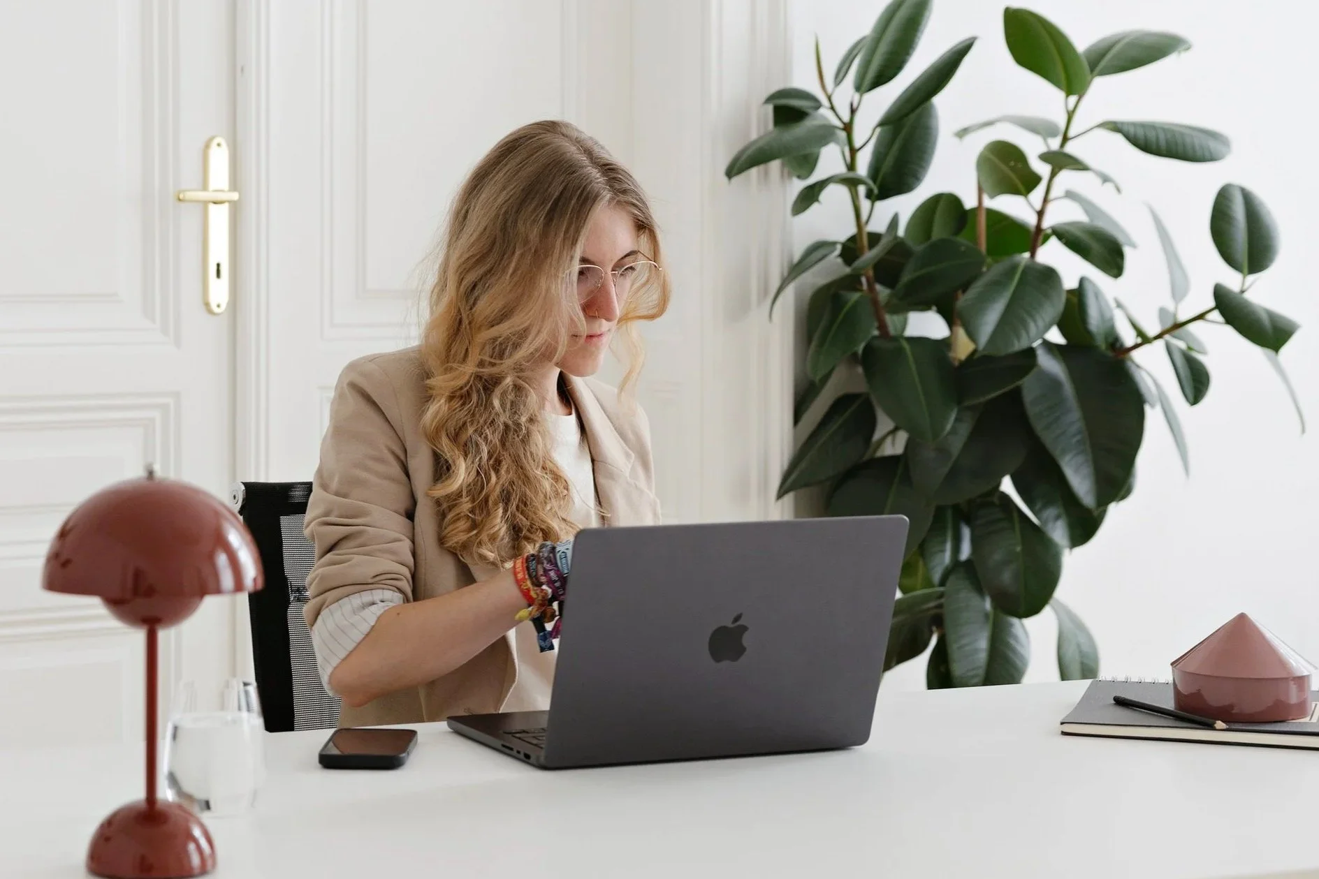 Celina Klestorfer, Gründerin von Bloom Studio - eine blonde Frau die auf ihrem MacBook arbeitet.