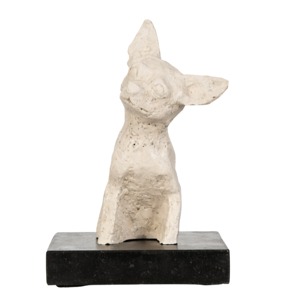 Een witte beeldhouwwerk van een kat, geplaatst op een zwarte sokkel.