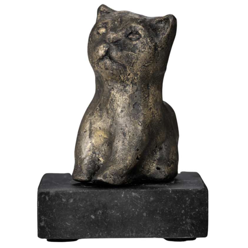 Een kleine, oude beeldhouwwerk van een kat van brons of een ander metaal, geplaatst op een vierkante donkere basis.