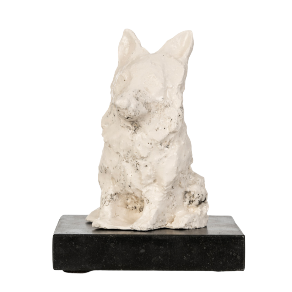 Een witte sculptuur van een kat op een zwarte basis.