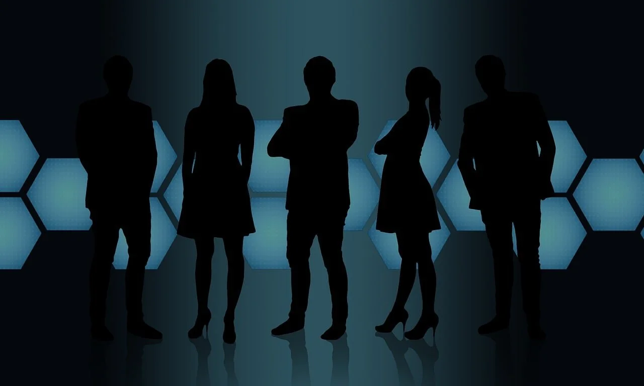 Silhouettes of five people standing in front of a futuristic background with glowing hexagonal panels.