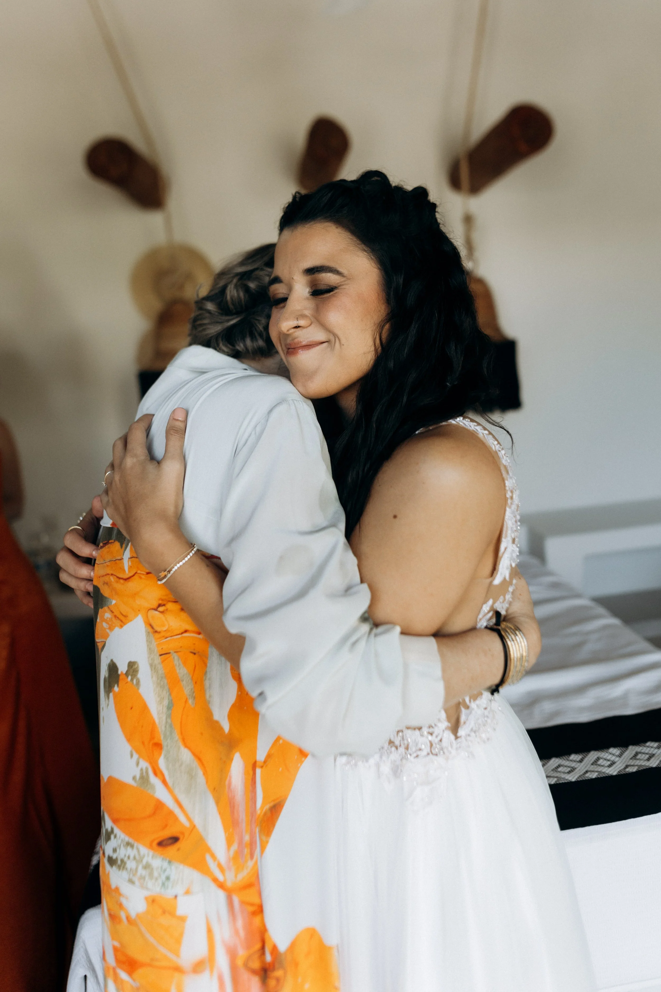 Mother and daughter hugging warmly during intimate wedding.