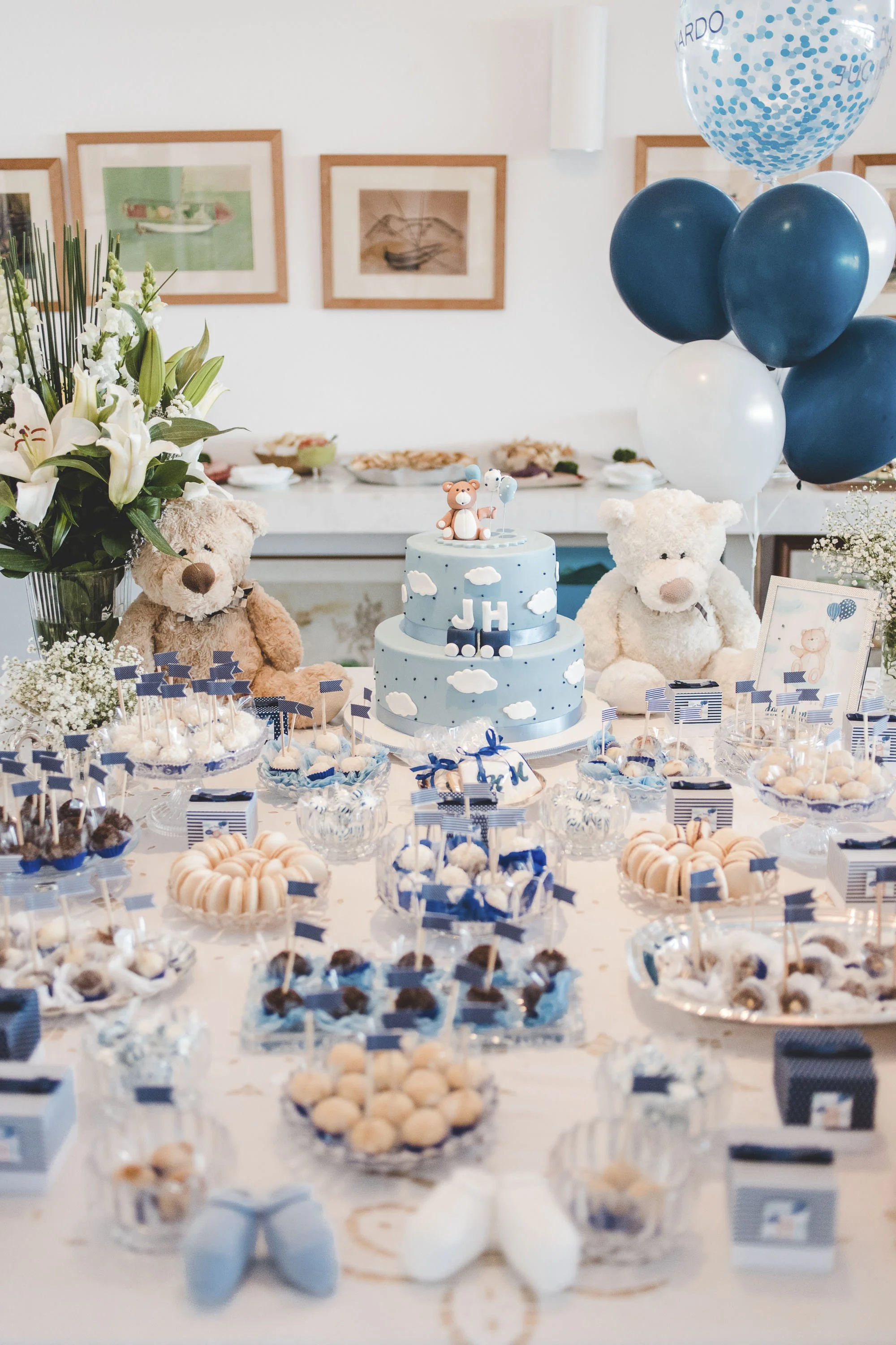 Detail shot of a baby shower celebration with blue-themed decorations, cake, balloons, and floral arrangements.