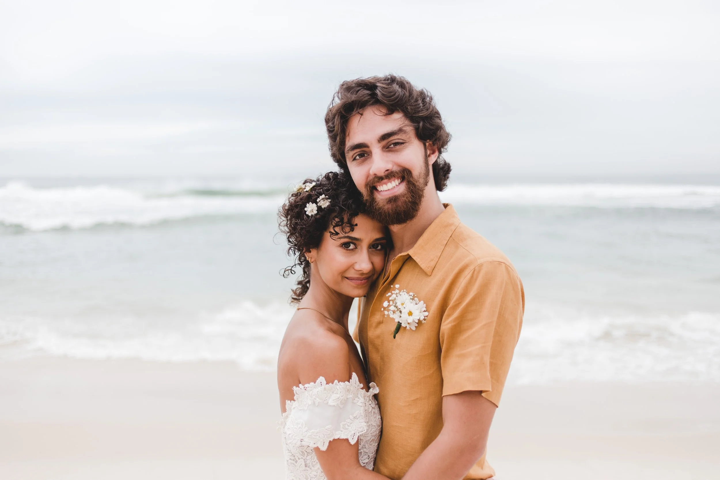 A couple embracing on the beach during an intimate wedding or elopement photo session.