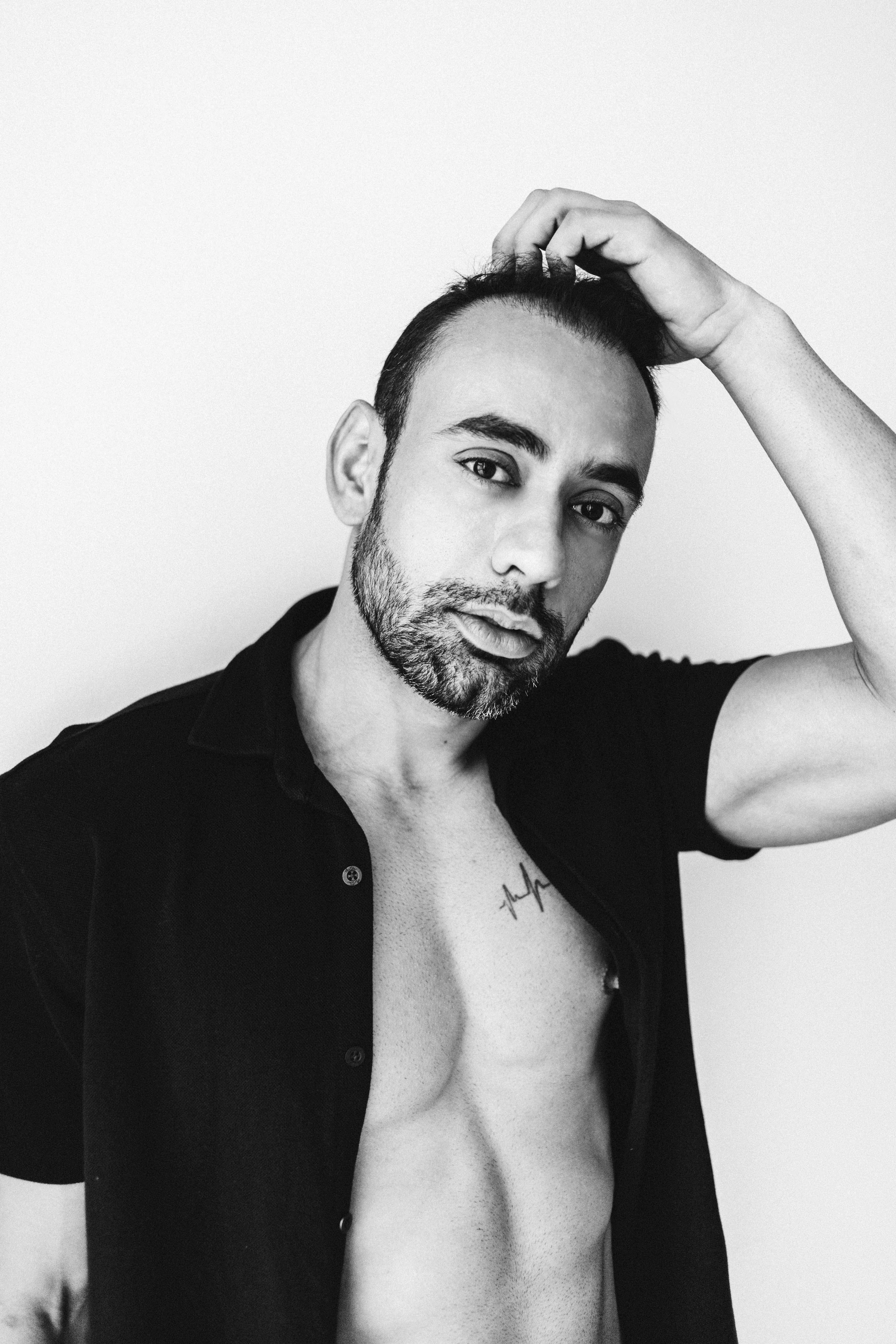 Black and white portrait of a man during a relaxed boudoir photo session.