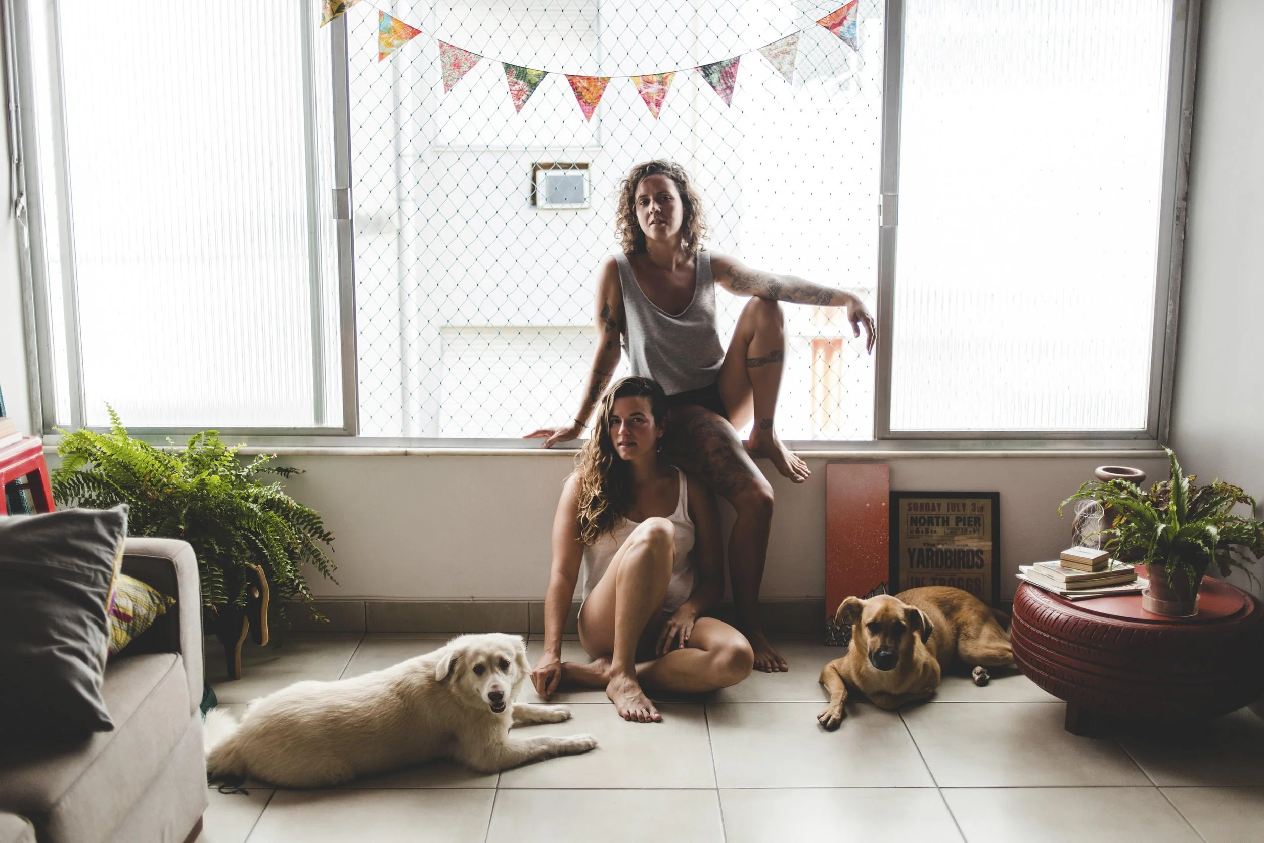 A lesbian couple with their two dogs during a relaxed lifestyle photo session at home.