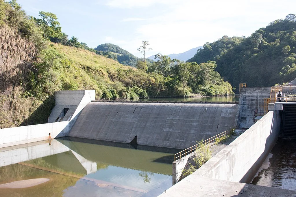 Embalse y represa en un entorno montañoso con vegetación.